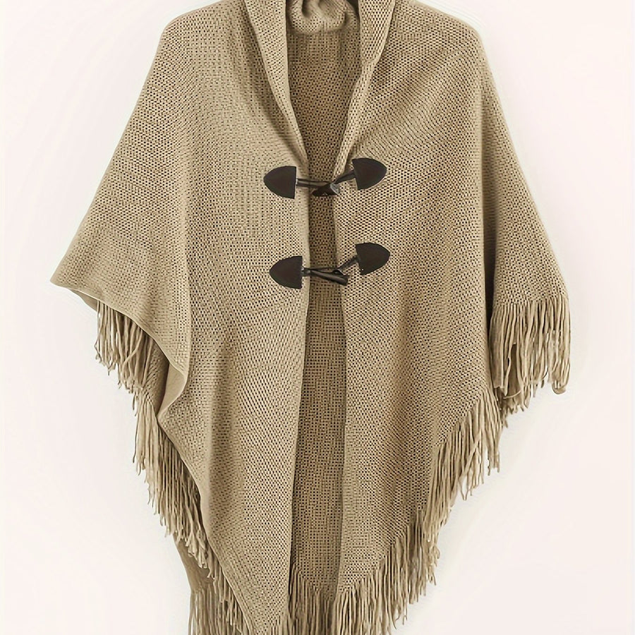 Poncho med tofsar och spännen, stickad i kamelfärg