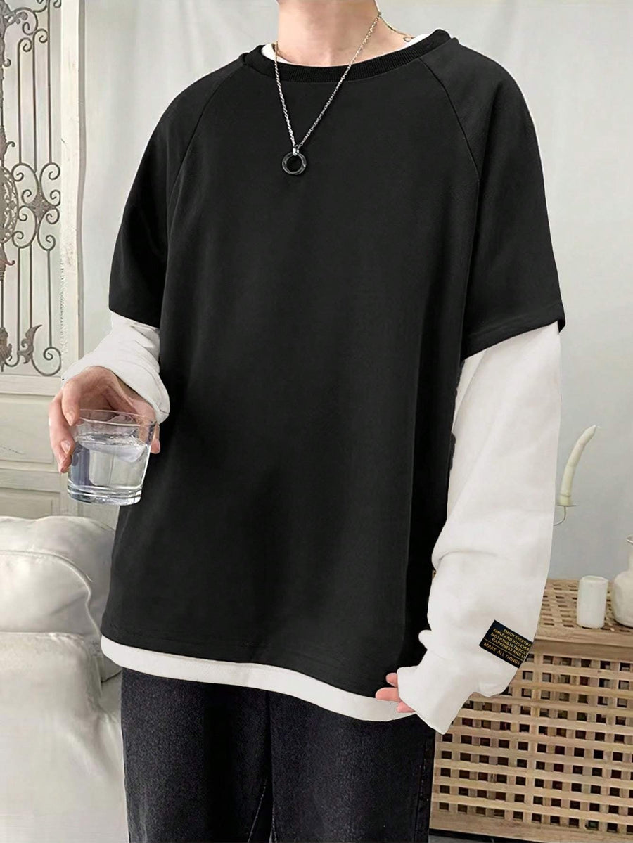 Svart T-shirt med vita långärmade ärmar och lager på lager-look