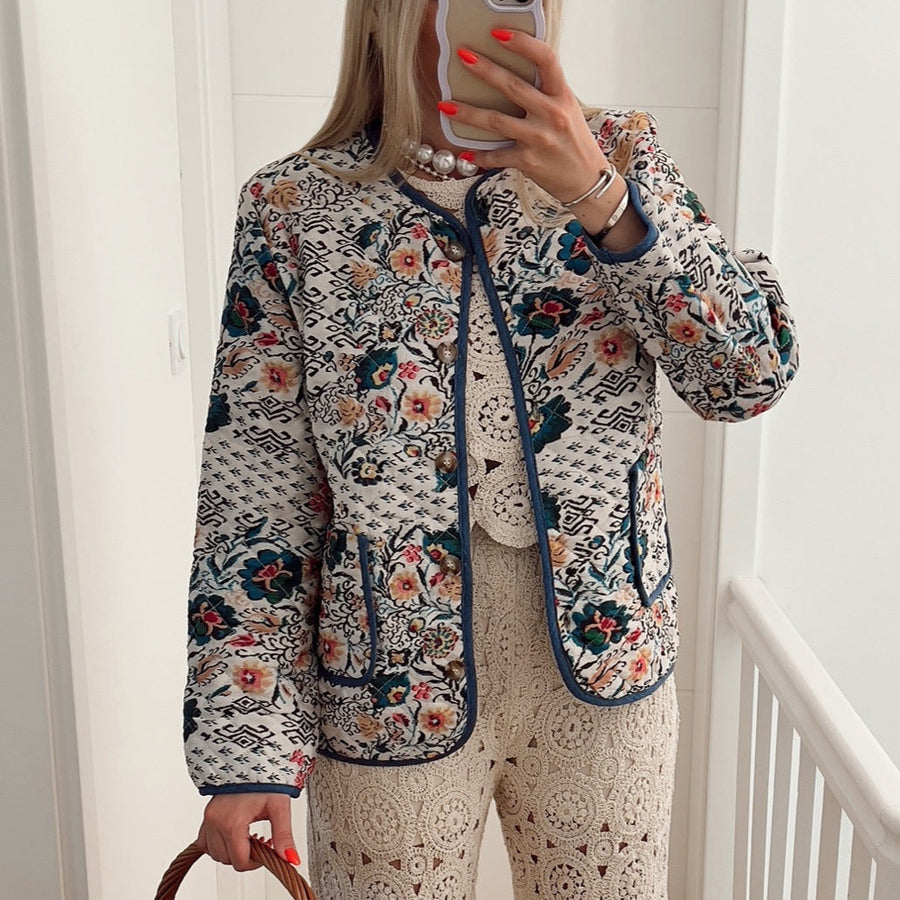 Quiltad jacka med blommönster och kontrastkant