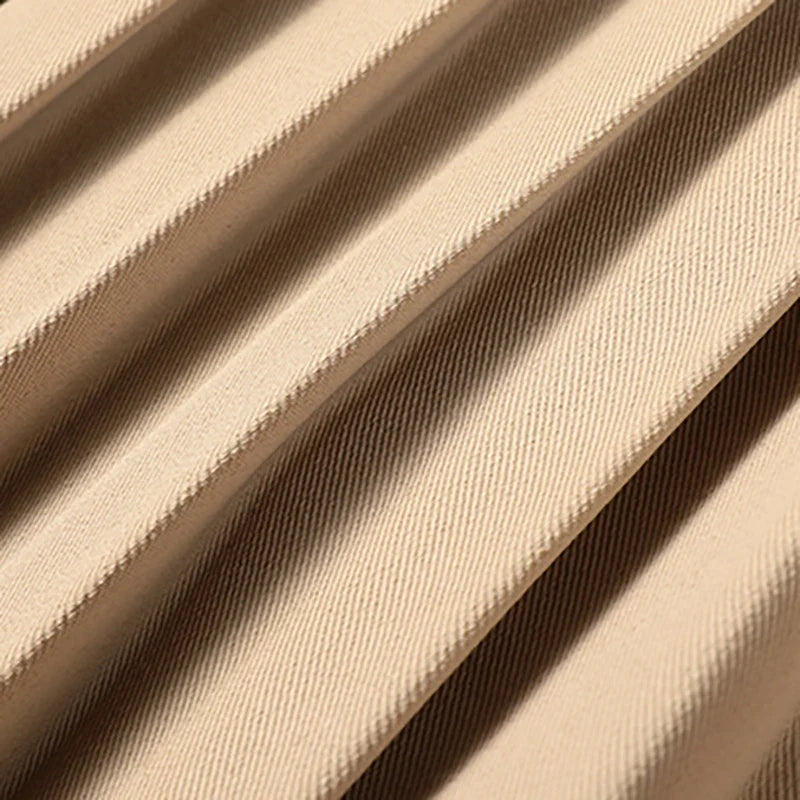 Beige trenchcoat med bälte och veckad kjoldel