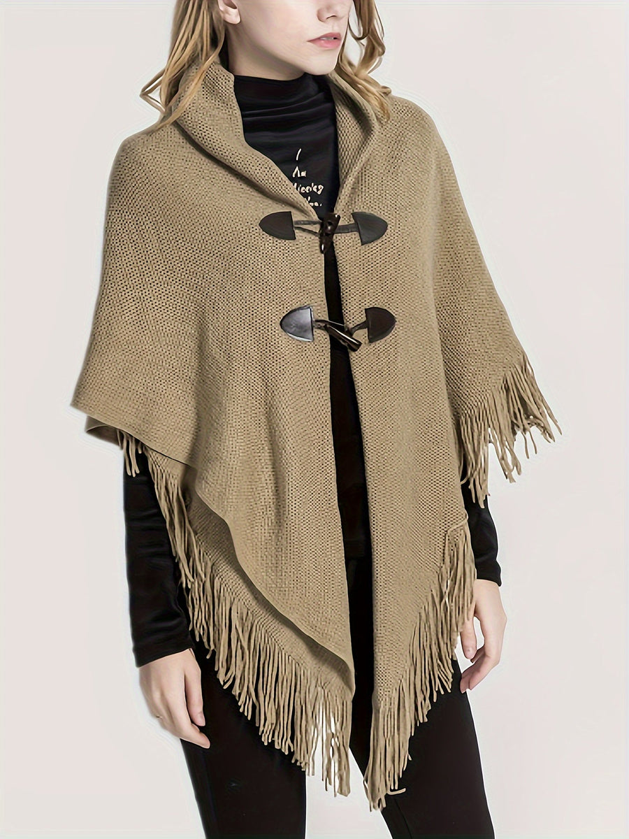 Poncho med tofsar och spännen, stickad i kamelfärg