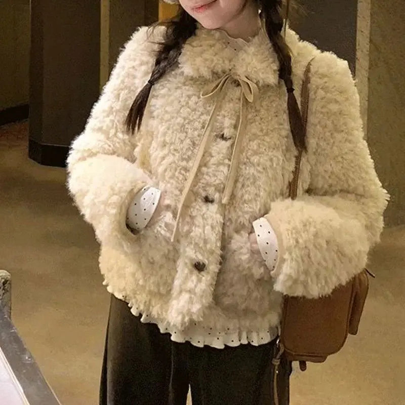 Teddyjacka i krämvitt med knappar och rosettbindning, fluffigt material