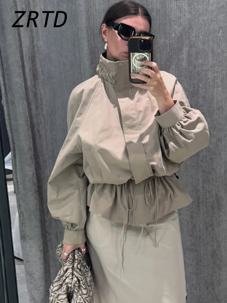 Beige vindjacka med huva voluminösa ärmar och dragsko i midjan för dam