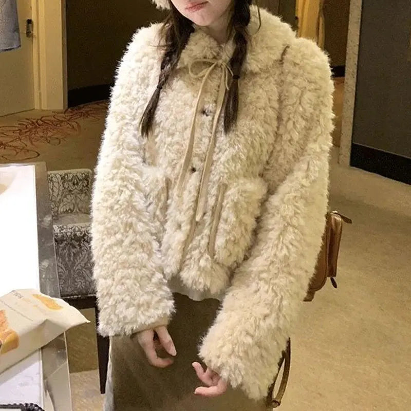 Teddyjacka i krämvitt med knappar och rosettbindning, fluffigt material