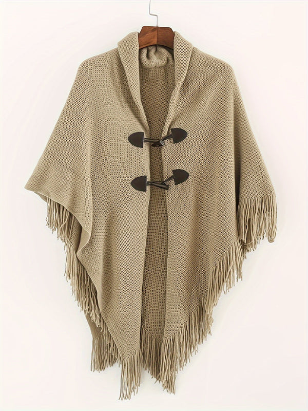 Poncho med tofsar och spännen, stickad i kamelfärg
